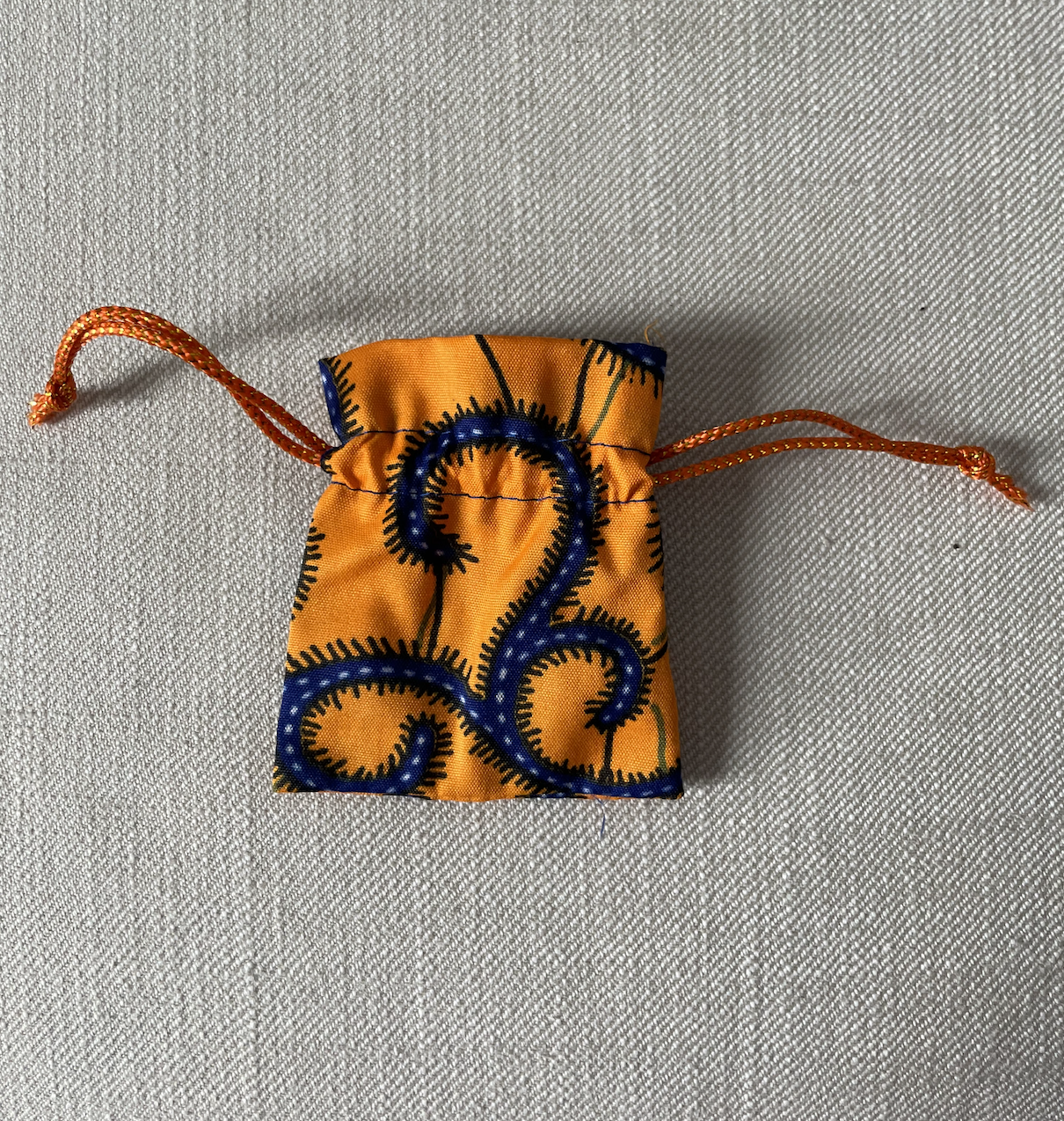 Sachet en WAX orange et bleu, offert pour le rangement de vos colliers de ventre